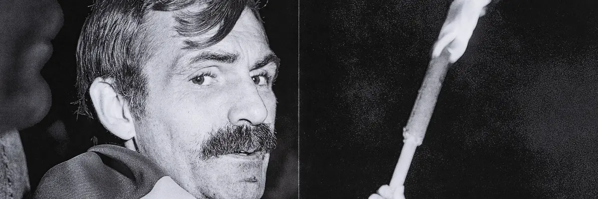 Die Schwarz-Weiß-Fotografie eines Mannes, der eine Flagge um die Schultern trägt.