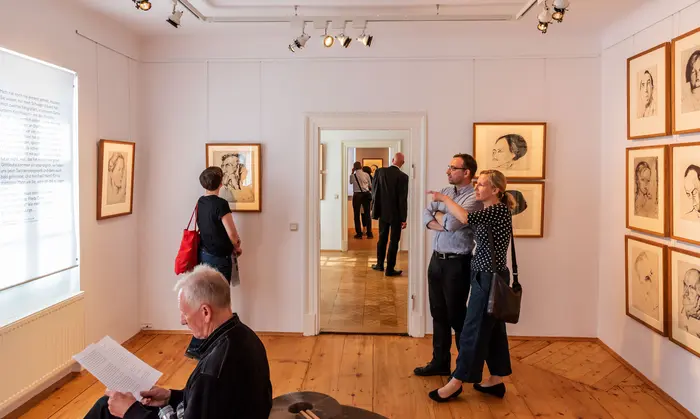 Besucher in einem kleinen Ausstellungsraum.