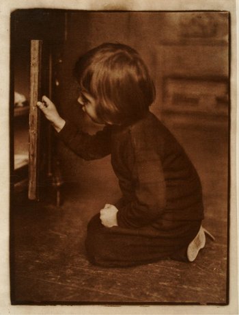 Fotografie eines kleinen Jungen, der vor einem Schrank kniet