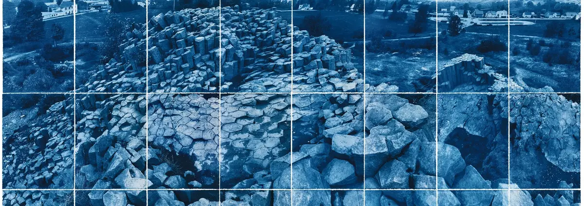 Die blau gefärbte Fotografie einer Felsformation.