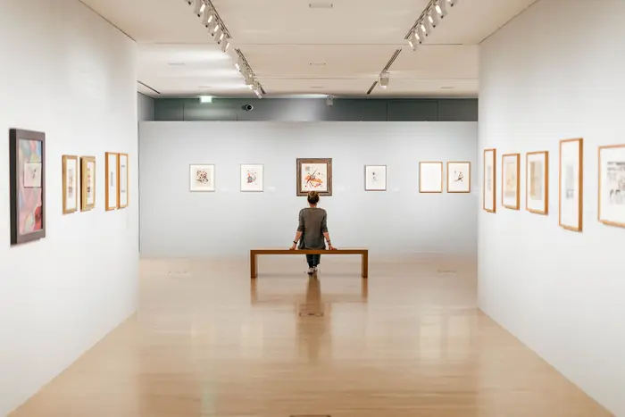 Raumansicht mit Kunstwerken und Besucherin 