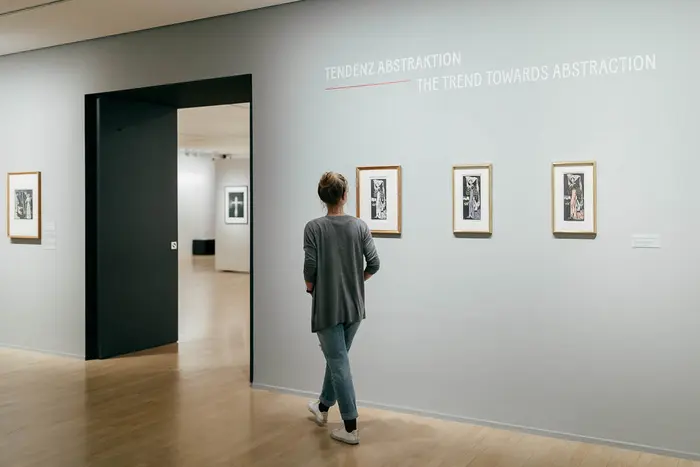 Raumansicht mit Kunstwerken und Besucherin