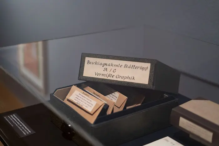 Eine schwarze Box mit der Aufschrift "Beschlagnahmte Blätter" in einem Glaskasten.