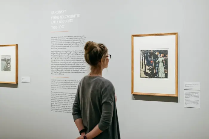 Raumansicht mit Kunstwerken und Besucherin