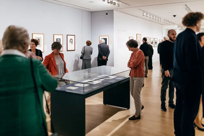 Raumansicht mit mehreren Besuchern.