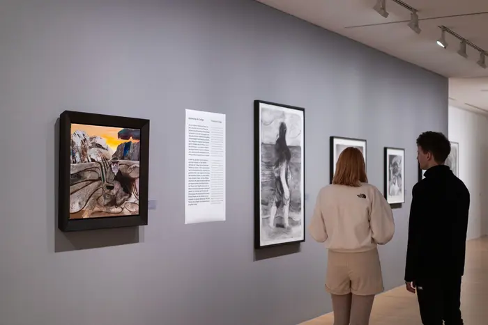 Raumansicht mit zwei Personen, die sich Kunstwerke anschauen