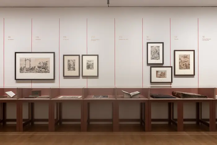 Eine Wand mit Gemälden und Glasschaukästen.