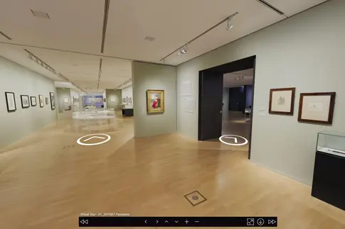 Ein Ausstellungsraum mit blassgrün bemalten Wänden und Holzboden.