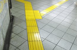 Olaf Holzapfel, "Unbestechliche Archive" - Blatt 6 (gelbe Fliesen, nach links und rechts verzweigend) Gelbe, mit linienförmigen Erhebungen bedeckte Fliesen heben sich als Abzweigung von einem grauen Fliesenboden ab.