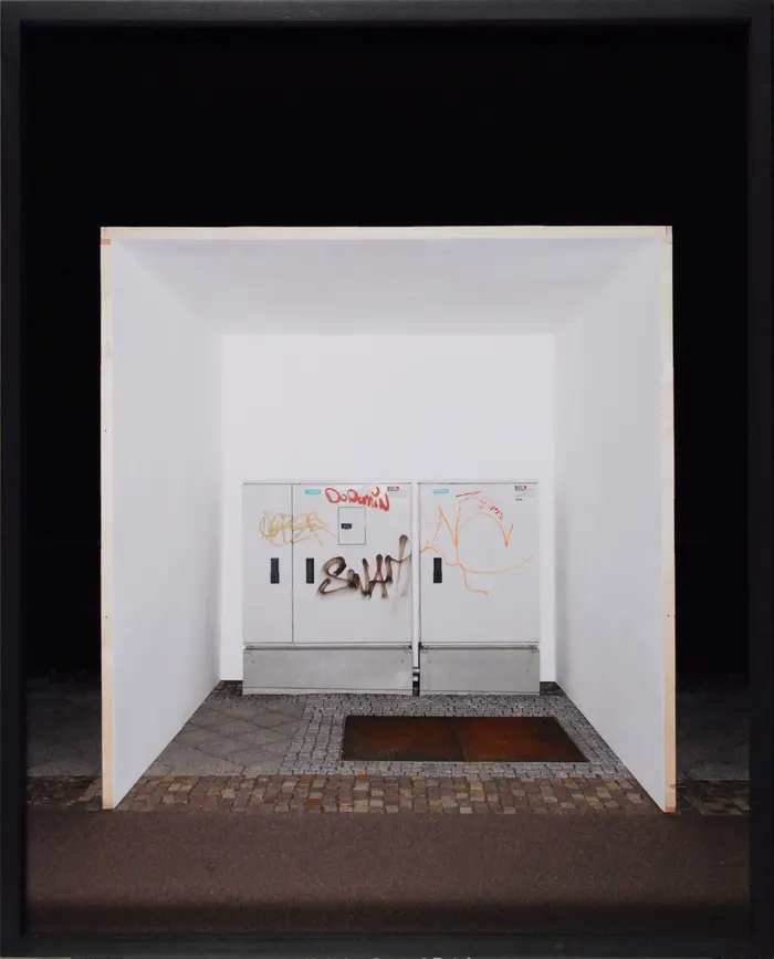 Eine Collage kombiniert eine Nachtstraße, einen weißen Raum und einen mit Graffiti besprühten eisernen Kasten. 