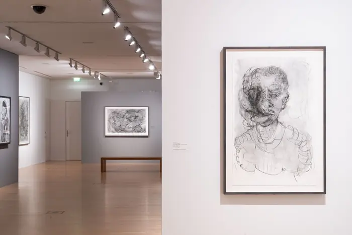 Raumansicht, im Vordergrund eine Zeichnung eines Mannes, dessen linke Gesichtshälfte nicht erkennbar ist