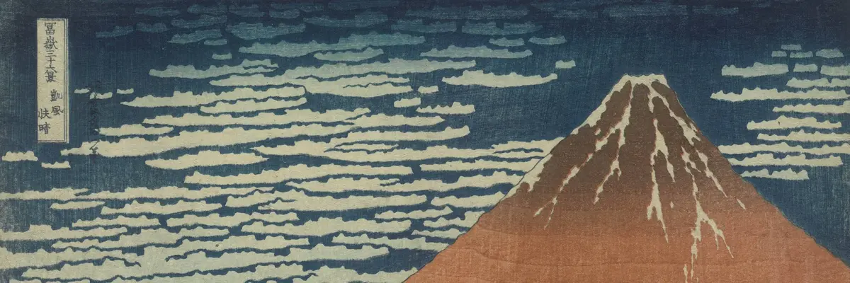 Roter Berg vor blauem Himmel mit weißem Wind.