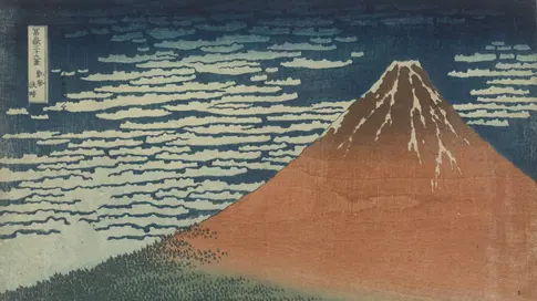 Roter Berg vor blauem Himmel mit weißem Wind.