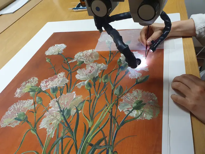 Ein Gemälde wird mithilfe technischer Geräte restauriert.