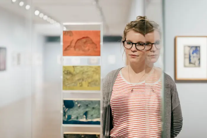 Raumansicht mit Kunstwerken und Besucherin