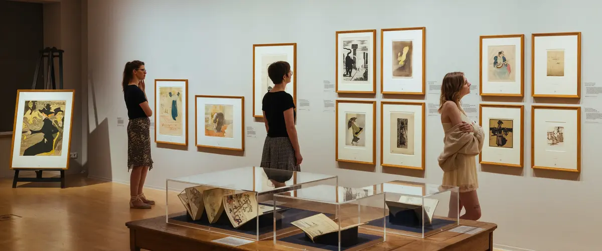 Ausstellungsansicht "Japan auf Papier in Dresden" im Kupferstich-Kabinett, Staatliche Kunstsammlungen Dresden 3 Frauen stehen vor einer Wand mit gerahmten Bildern auf Papier