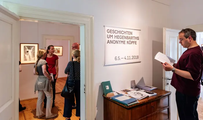 Besucher in einem kleinen Ausstellungsraum.