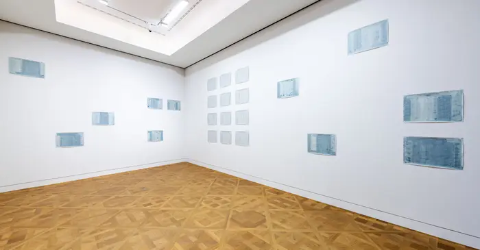 Ein Ausstellungsraum mit weißen Wänden und Holzboden.