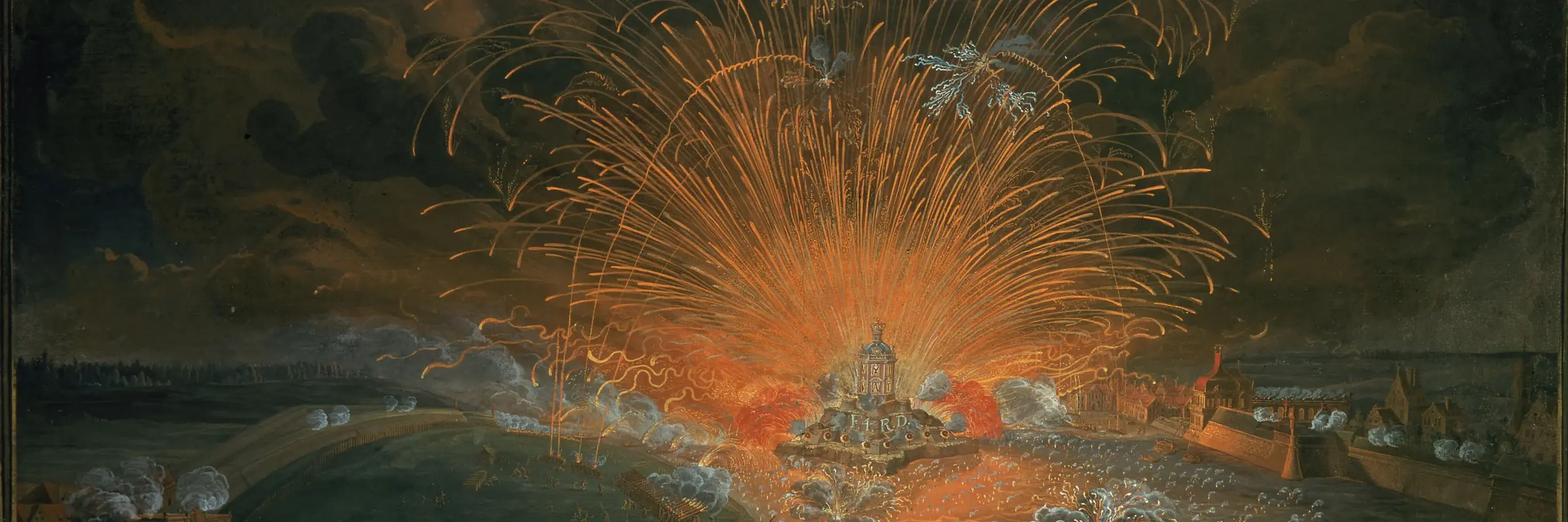 Ein orange-rotes Feuerwerk am Ufer eines Flusses bei Nacht.