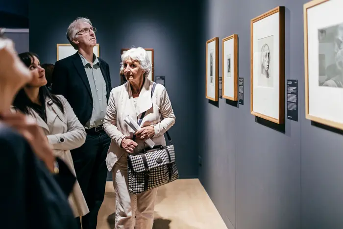 Raumansicht mit mehreren Besuchern.