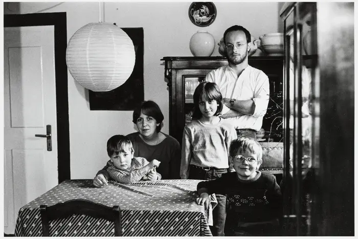 Schwarz-Weiß-Fotografie einer Familie im Esszimmer.