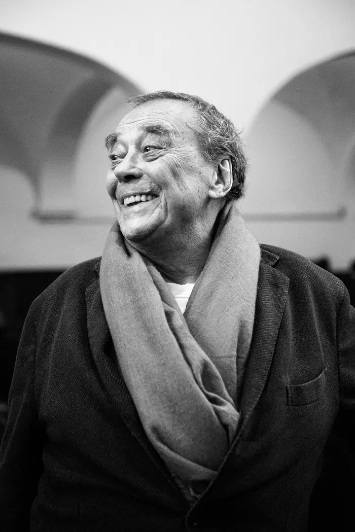 Das Porträtfoto eines lächelnden Mannes in Schwarz-Weiß.