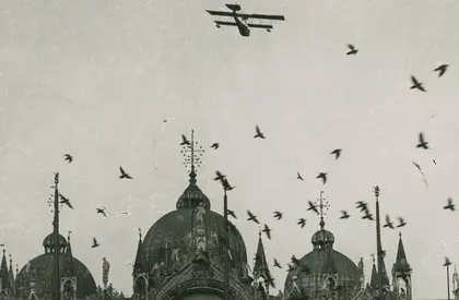 schwarz-weiß Foto eines Flugzeugs über dem Markusplatz in Venedig