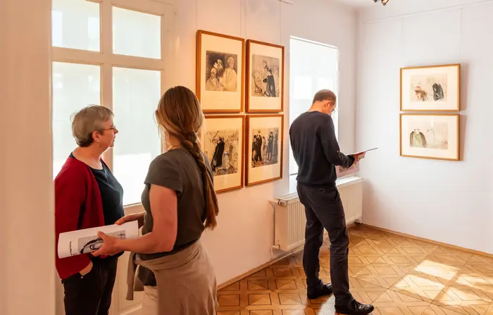 Menschen in einem lichtdurchfluteten Ausstellungsraum.