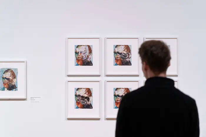 Raumansicht mit einer Person, die sich Kunstwerke anschaut