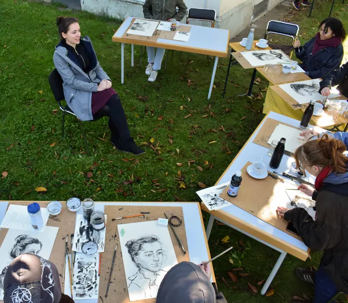 Menschen sitzen an Tischen uns zeichnen