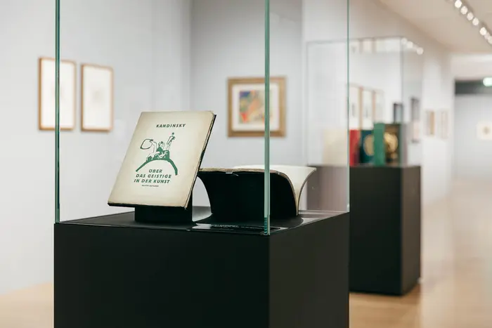 Raumansicht mit Kunstwerken und Besucherin