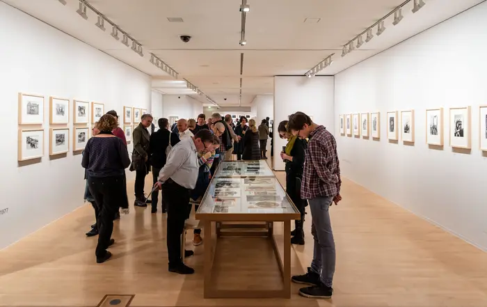 Menschen betrachten Kunstwerke in einem Ausstellungsraum.